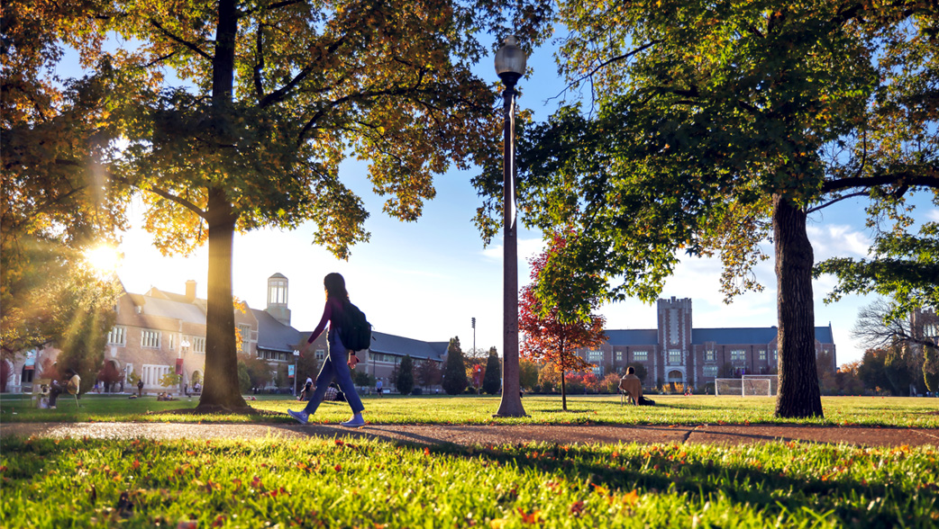 Student walks on campus on a fall afternoon