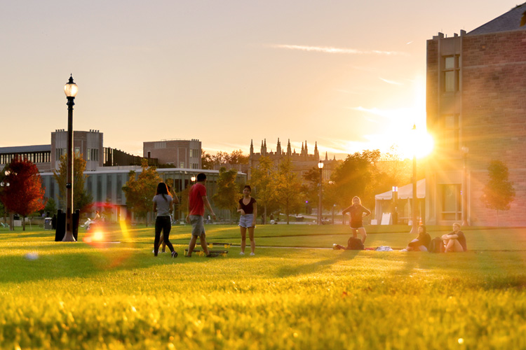 students on campus with sunset